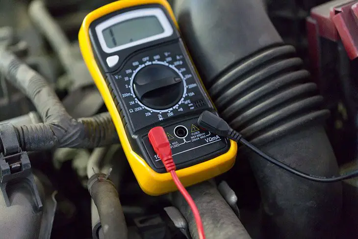 auto-service,-repair-and-maintenance-concept---digital-multimeter-or-voltmeter-testing-car-battery